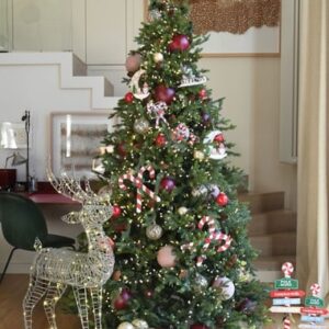 Sapin de Noël décoré avec boules, sucres d’orge et illumination LED, accompagné d’un renne lumineux pour une ambiance festive